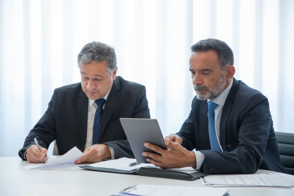 Profesionales revisando documentación y una tableta durante una reunión